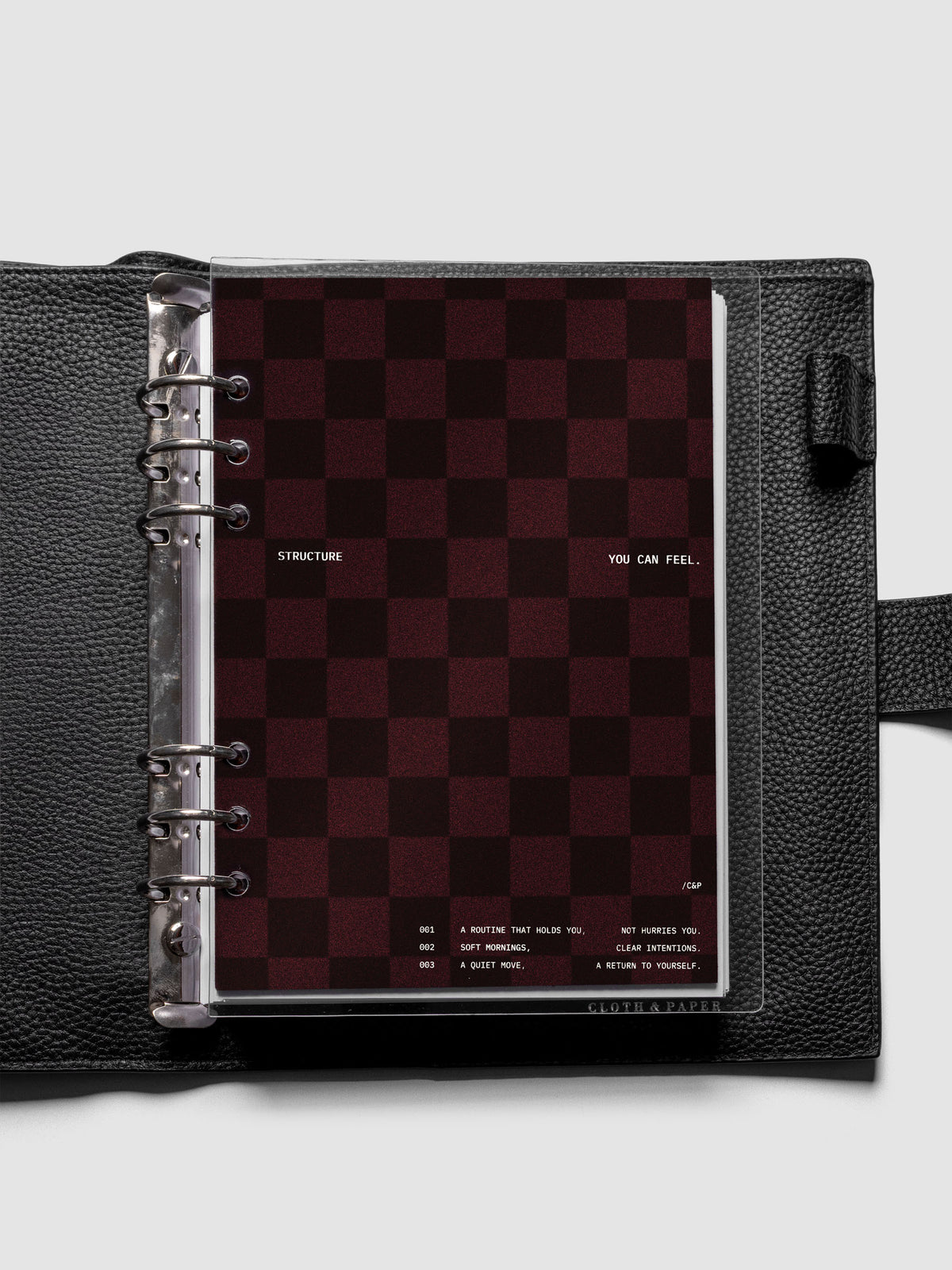 A5 sized velvet checkered dashboard in the color Bordeaux with crystal clear planner dashboard shown inside a black leather agenda.