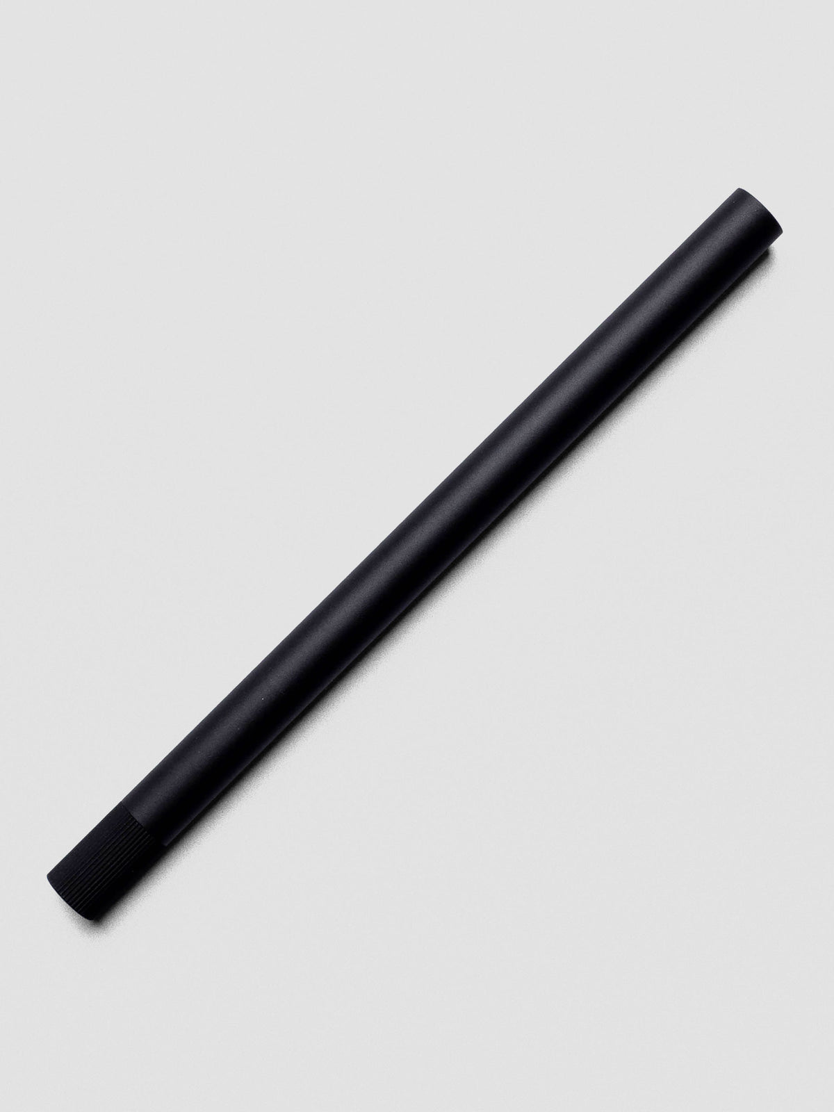 Lumos Pro Single Tip Pen in Matte Black, shown capped on neutral background.