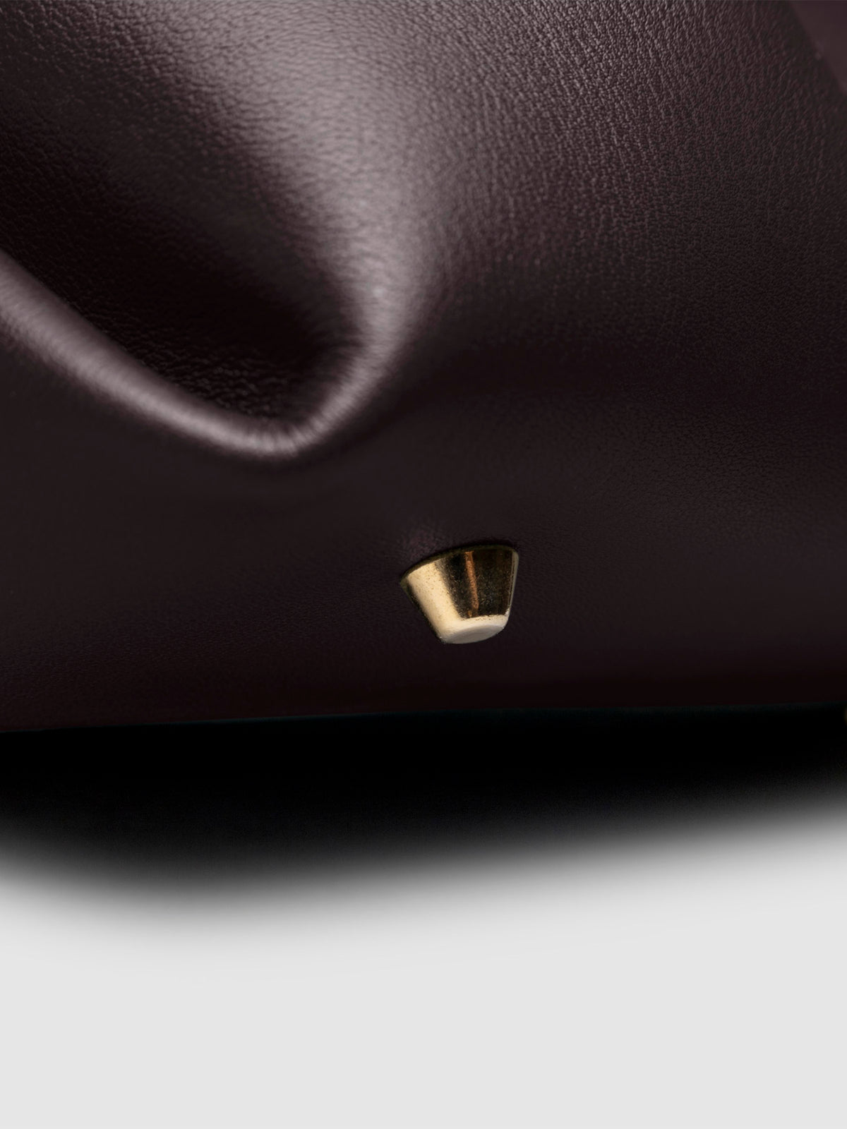Closeup of the gold feet on the bottom of the bag. Color shown is Madrid.