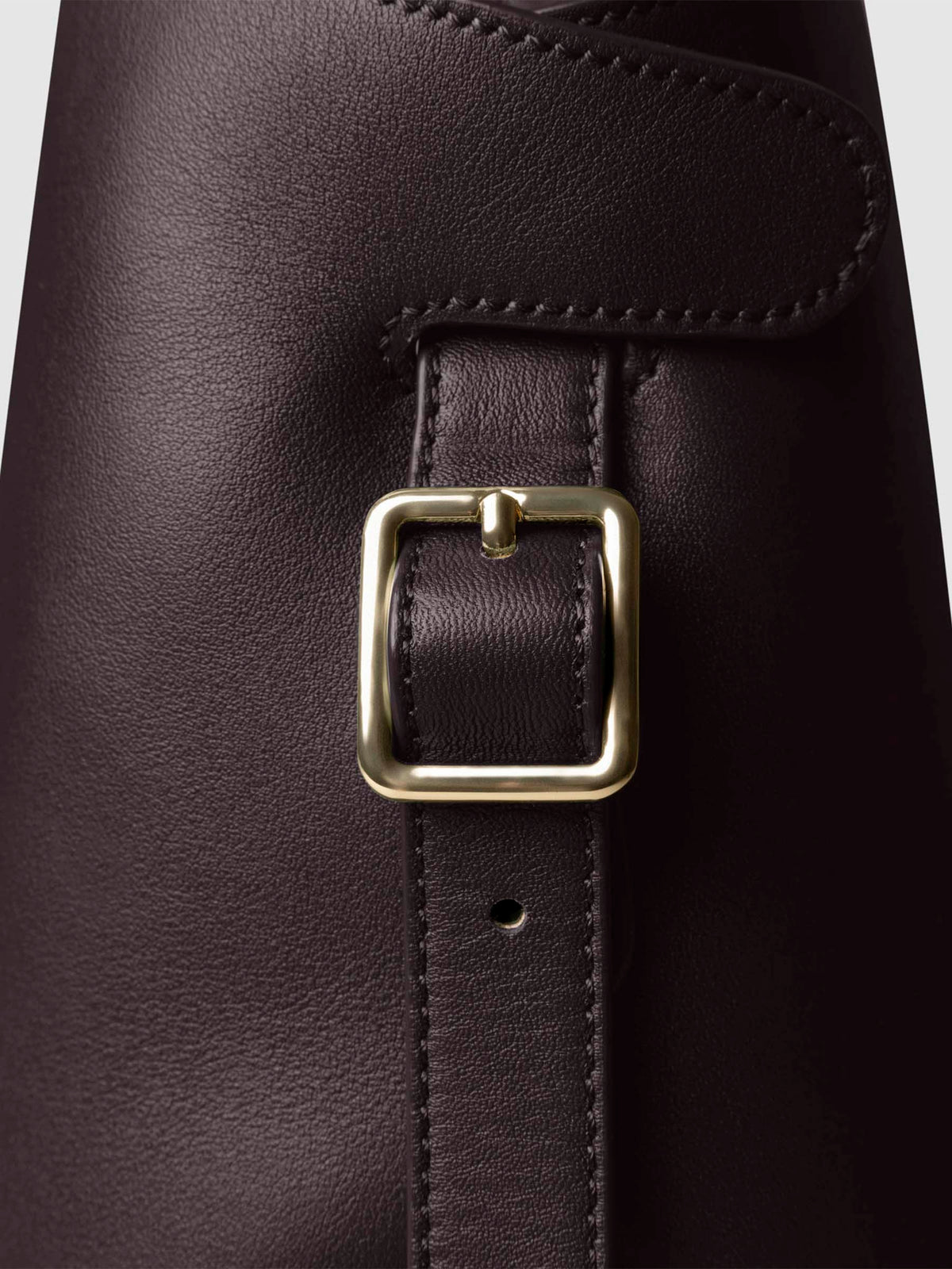 Side view of bag showcasing its gold hardware and adjustable leather strap. Color shown is Madrid.