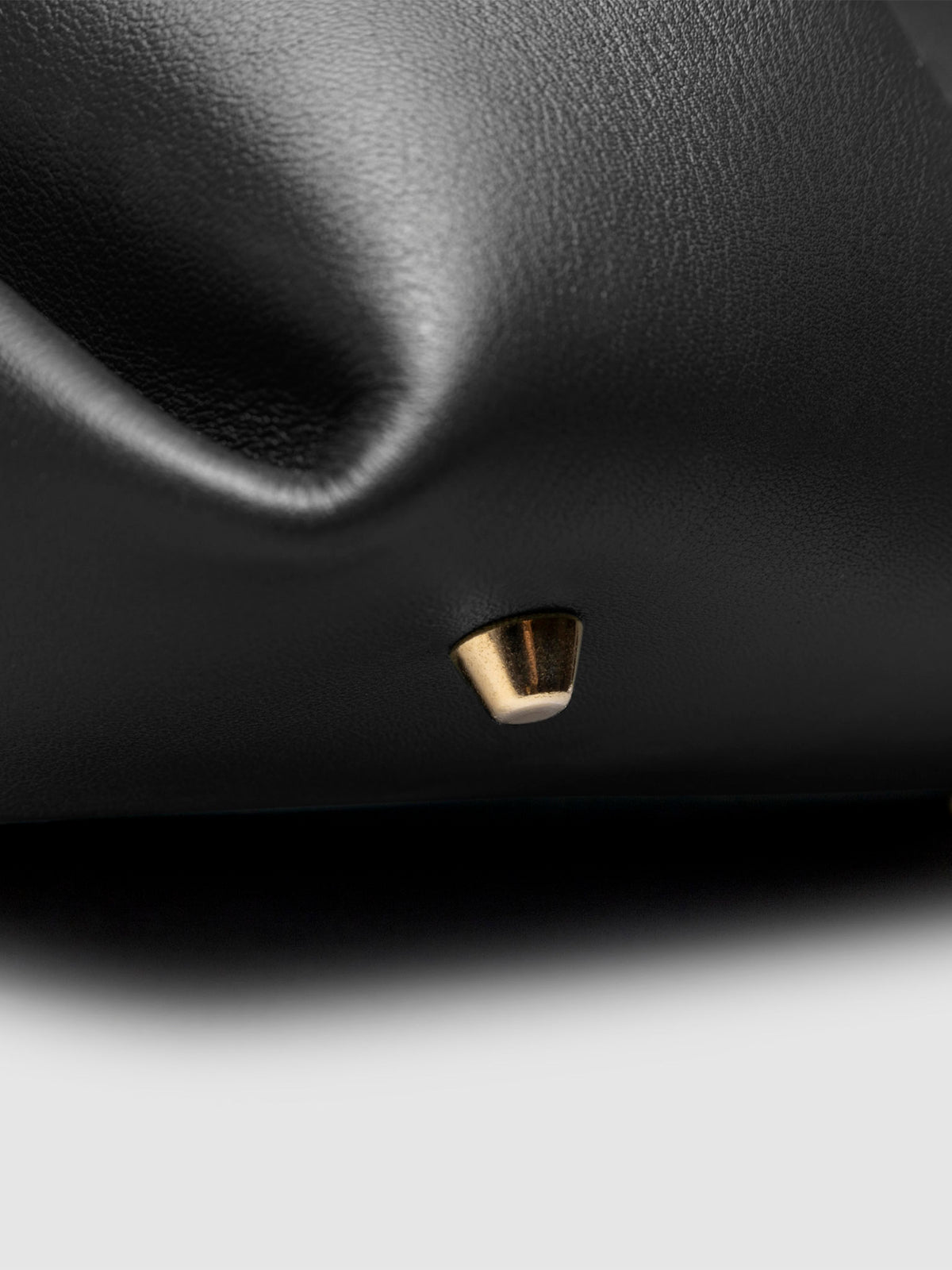 Closeup of the gold feet on the bottom of the bag. Color shown is Padrillo.
