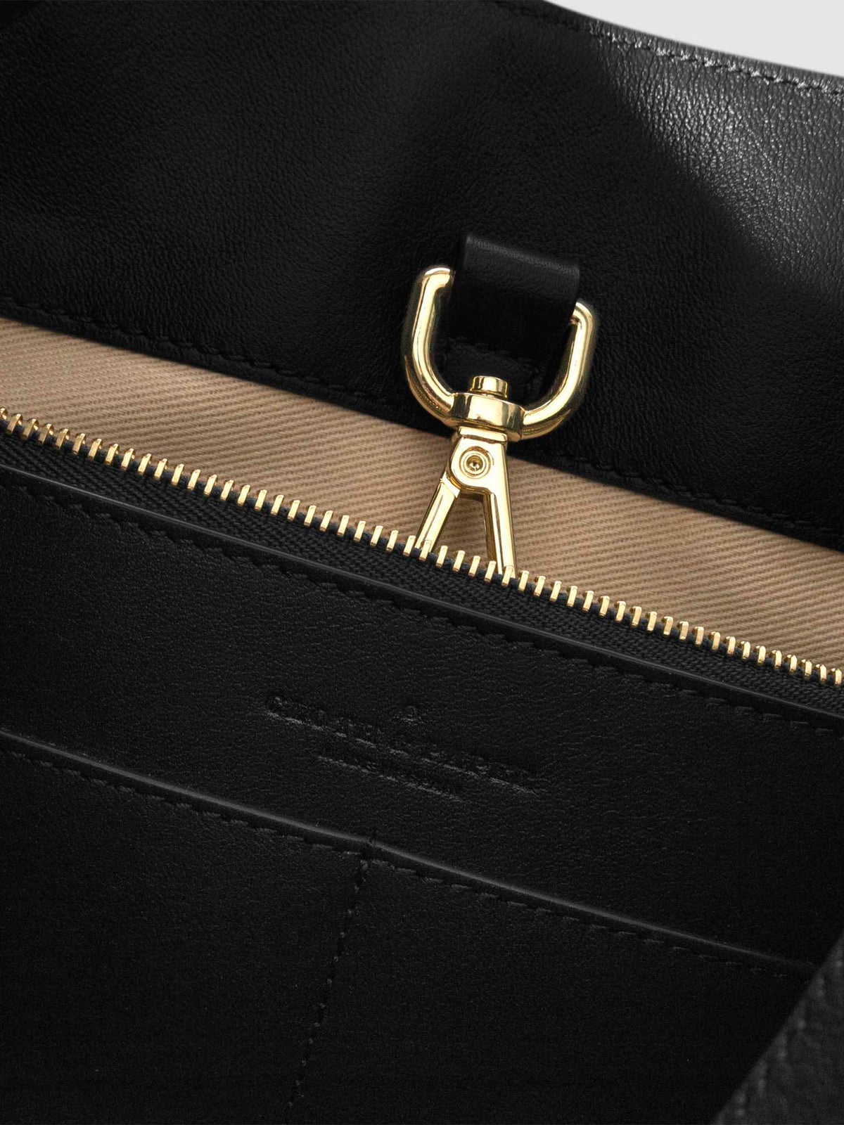 Top down view of bag showcasing its gold hardware. It secures the bag shut. Color shown is Padrillo.
