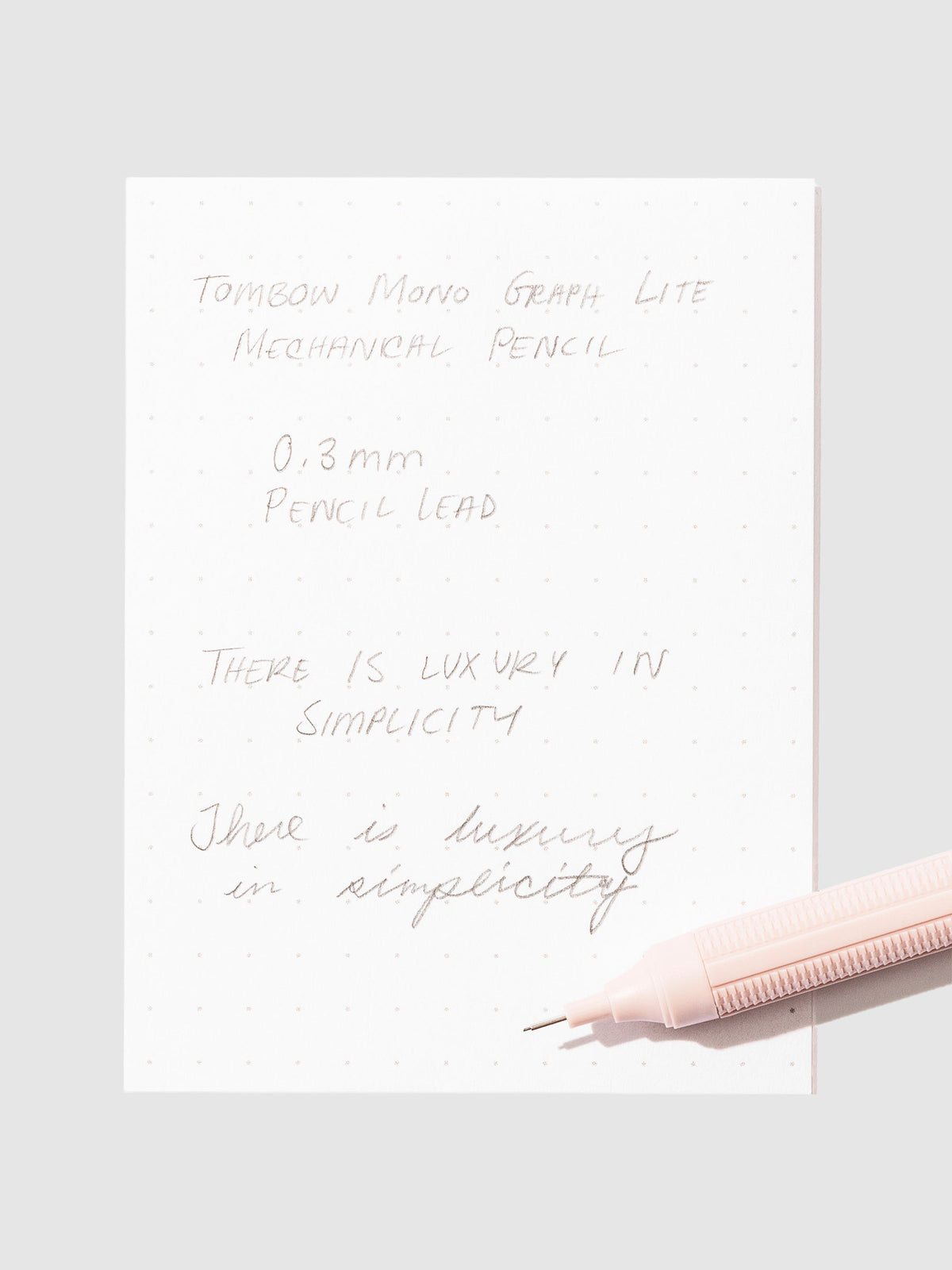 Writing sample with pencil displayed on a neutral background.