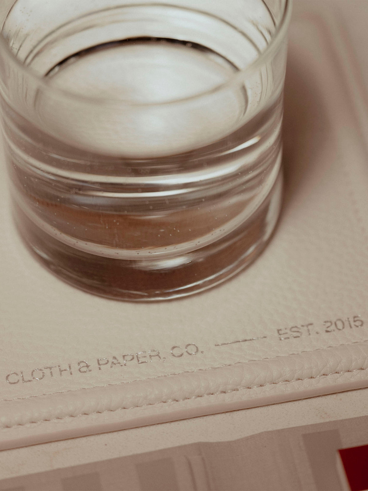 Trinket tray displayed on a neutral backdrop. A cup of water is placed on top of it.