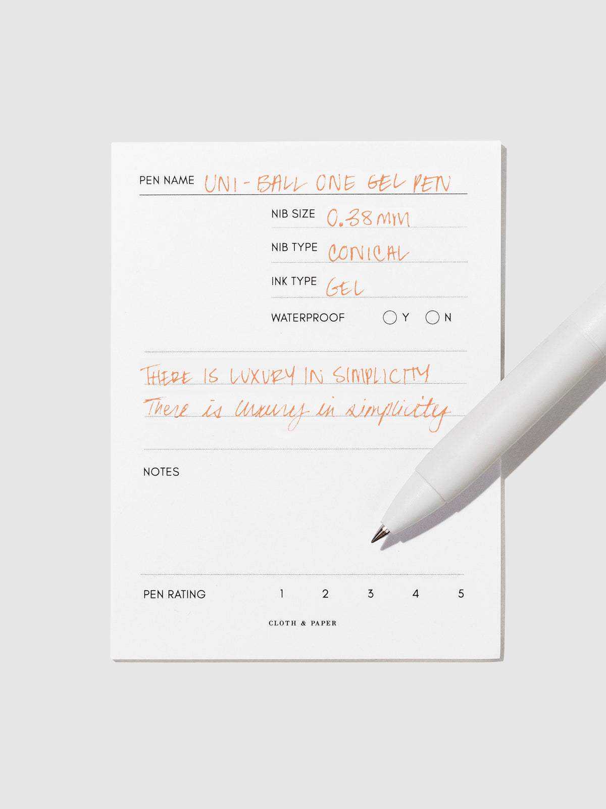 Pen tilted slightly to the right on a neutral background. Color pictured is Mango Orange.