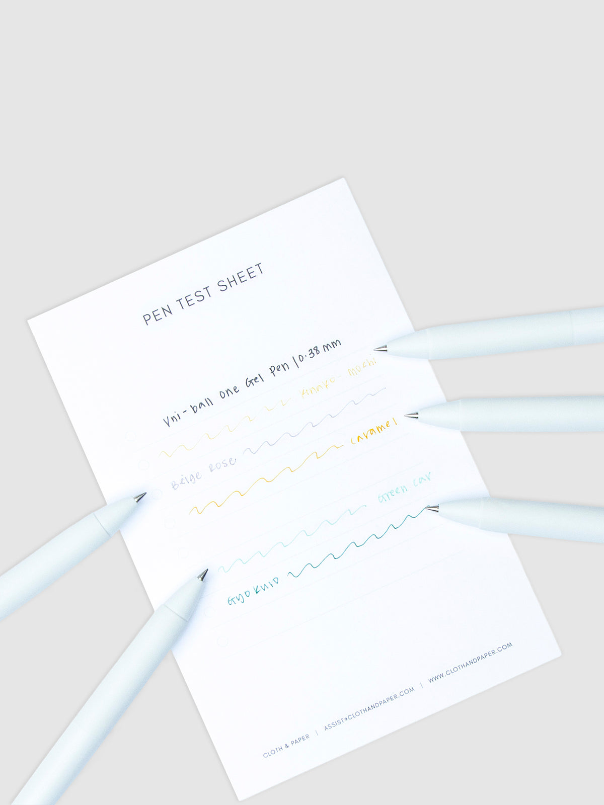 Pen test sheet showing ink samples for Kinako Mochi, Beige Rose, Caramel, Green Car, and Gyokuro ink. Five pens are resting on the edges of the pen test sheet.