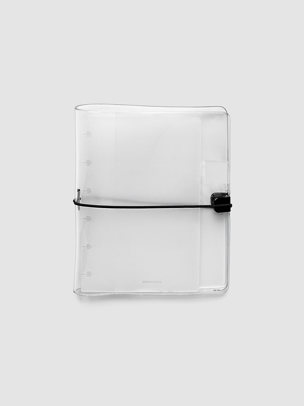 Clear Vinyl Planner Cover in size CP Petite shown empty and closed on a grey background.