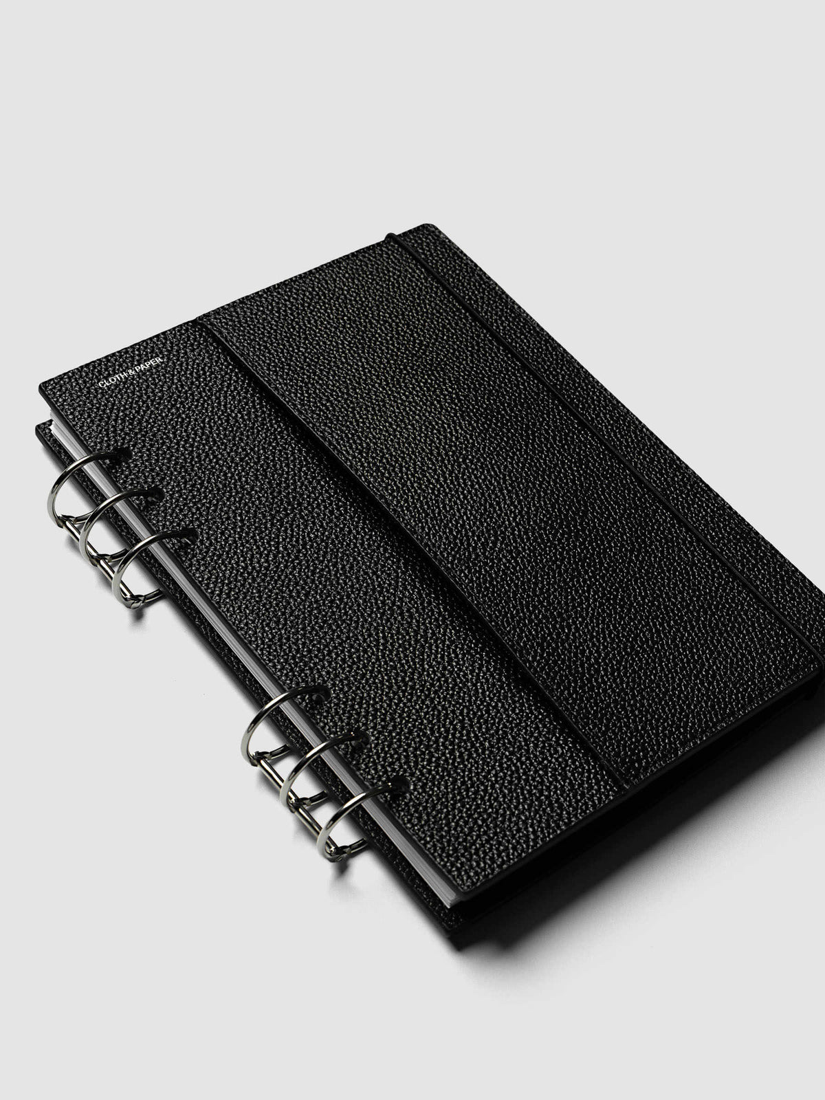 The A5 6-Ring Punch Genuine Leather Planner Cover Set closed at an angle on a ring bound planner, showing the depth of the assembled set