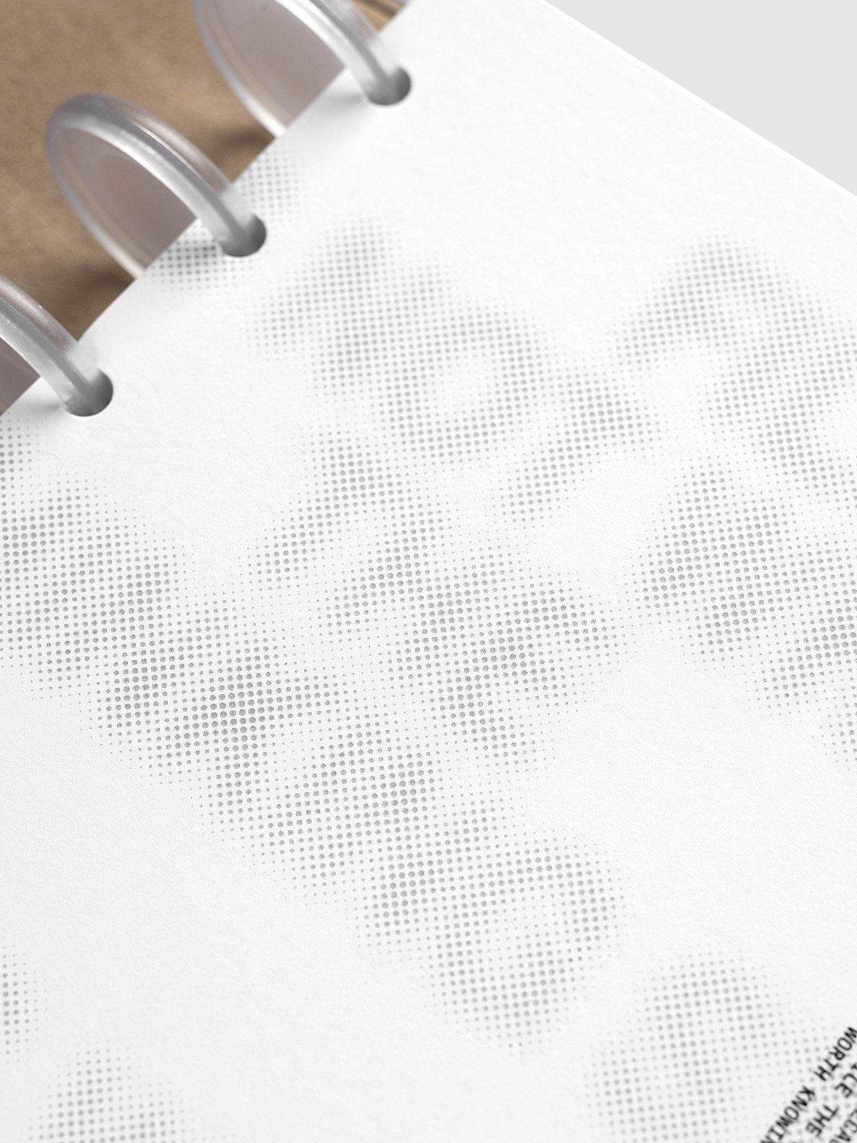 Halftone Planner Dashboard, Half Letter 8-Disc Punch, angled close-up of the frosted discs and the grey dotted lettering