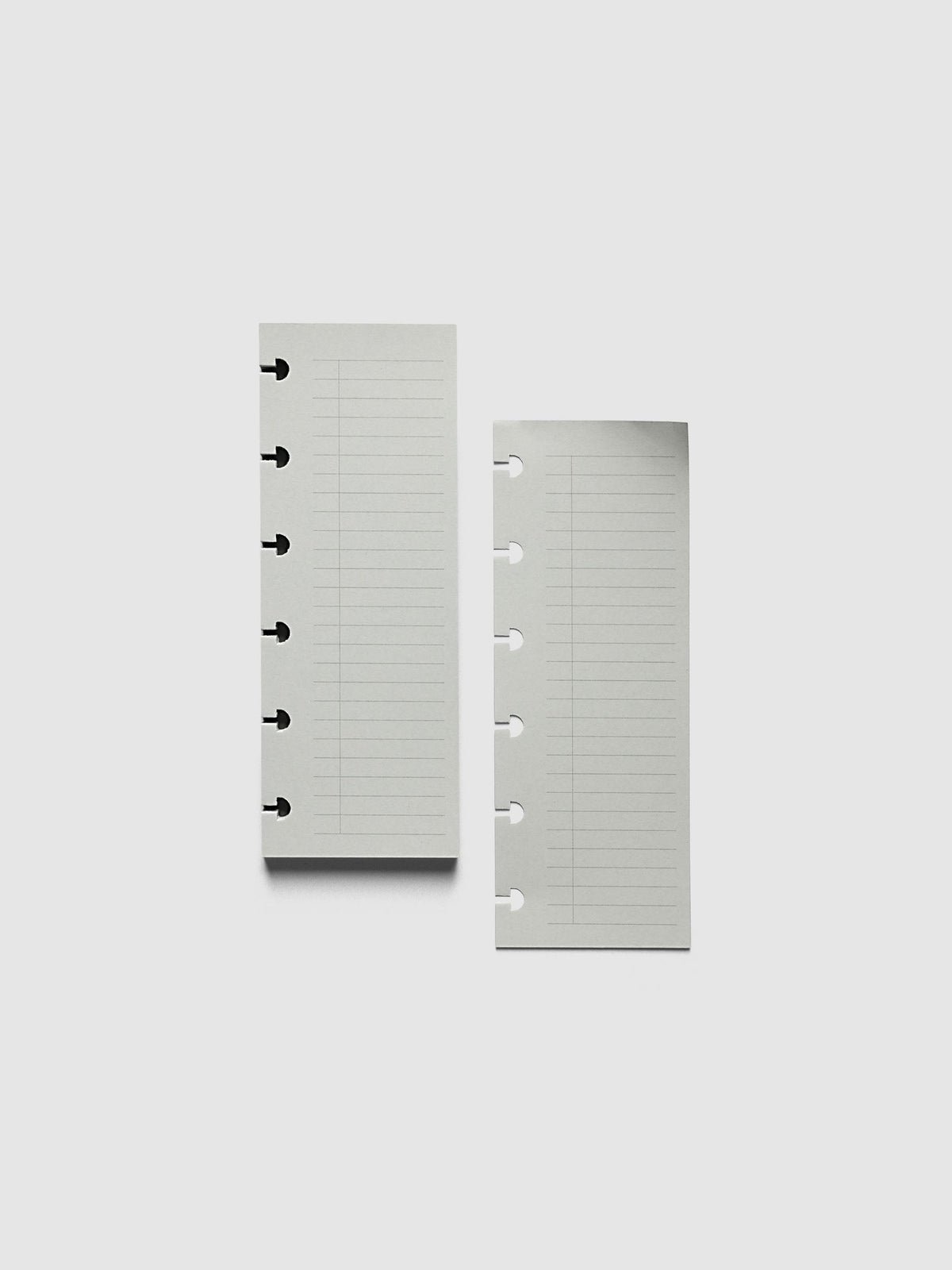 System Punch Pad, CP Petite 6-Disc Punch, a torn-off sheet lying beside the pad, disc notches along the left edge of each