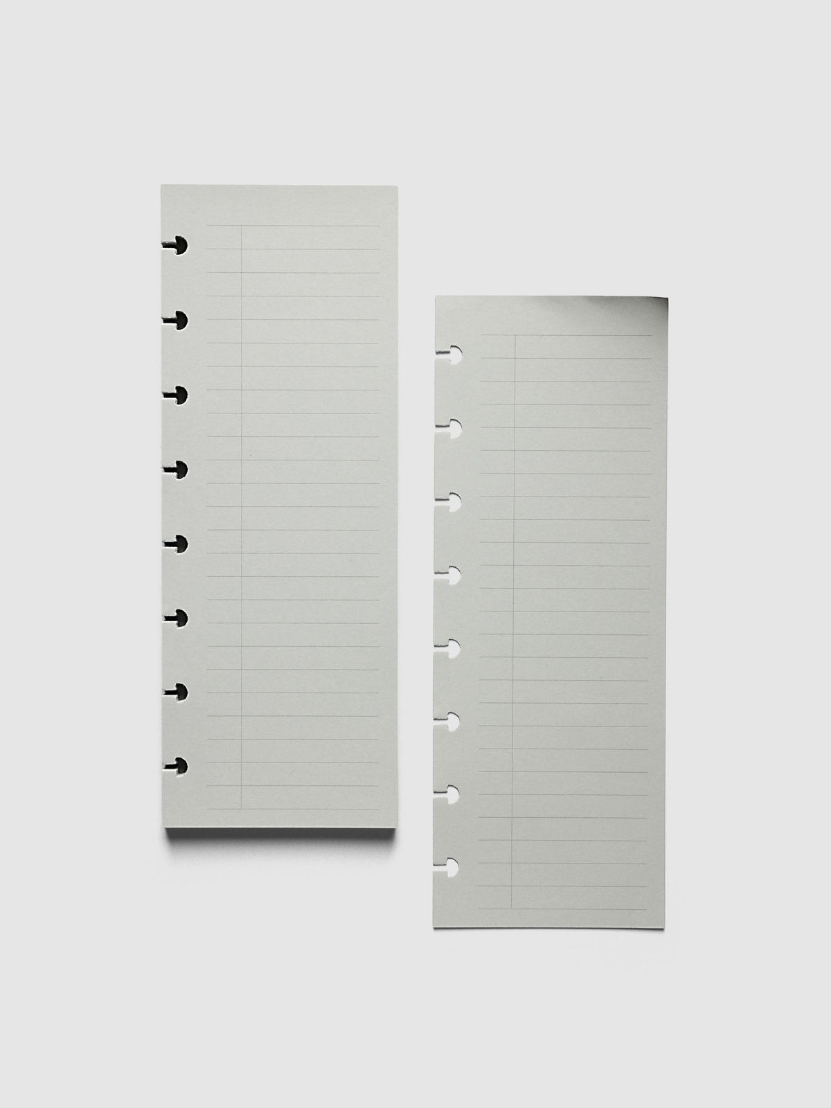 System Punch Pad, Half Letter 8-Disc Punch, a torn-off sheet lying beside the pad, disc notches along the left edge of each
