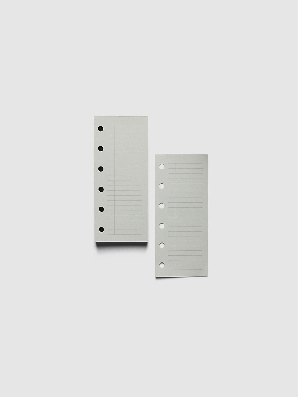 System Punch Pad, Pocket 6-Ring Punch, a torn-off sheet lying beside the pad, round ring holes along the left edge of each