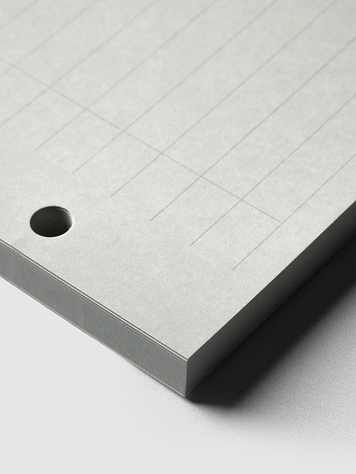 System Punch Pad, close-up of a round punch hole at the corner of the pad