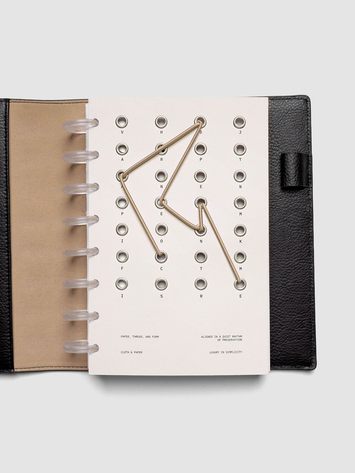 Cadence Dashboard with grommets and string on beige cardstock shown in size Half Letter for discbound planners and notebooks.