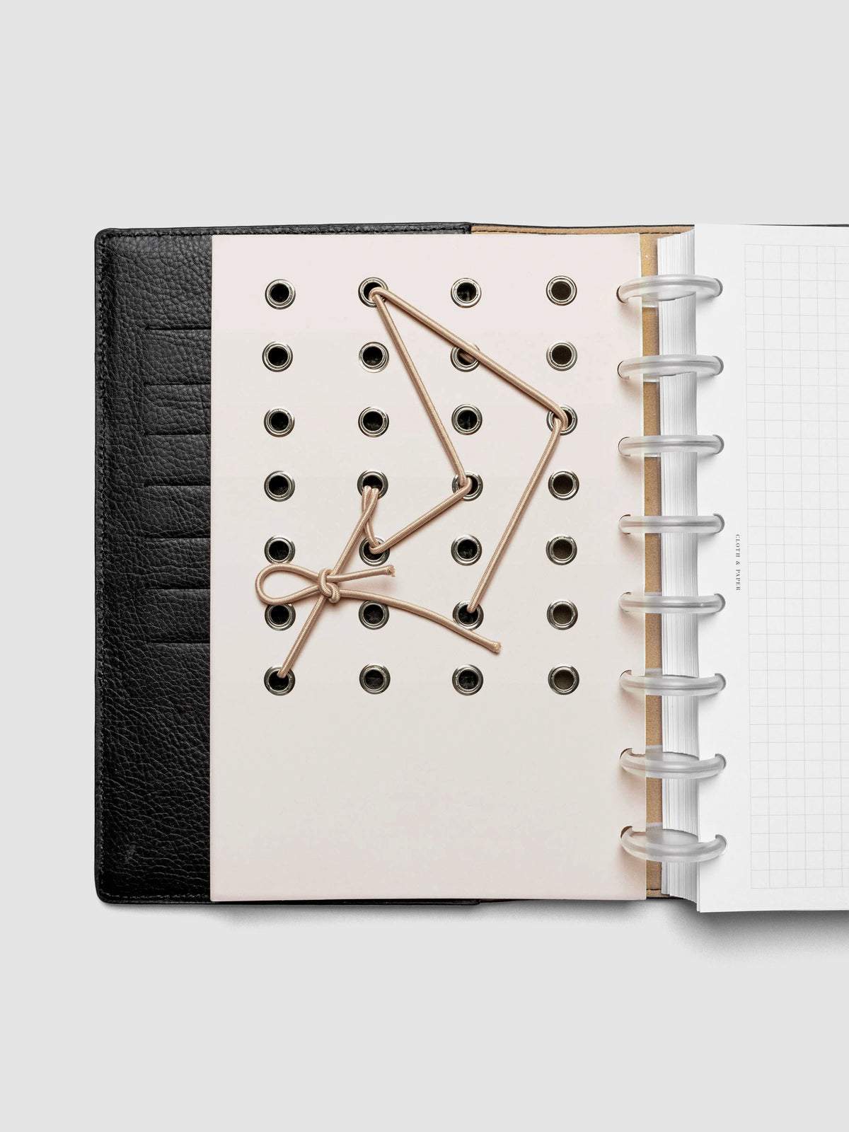 Cadence Dashboard with grommets and string on beige cardstock shown in size Half Letter for discbound planners and notebooks.