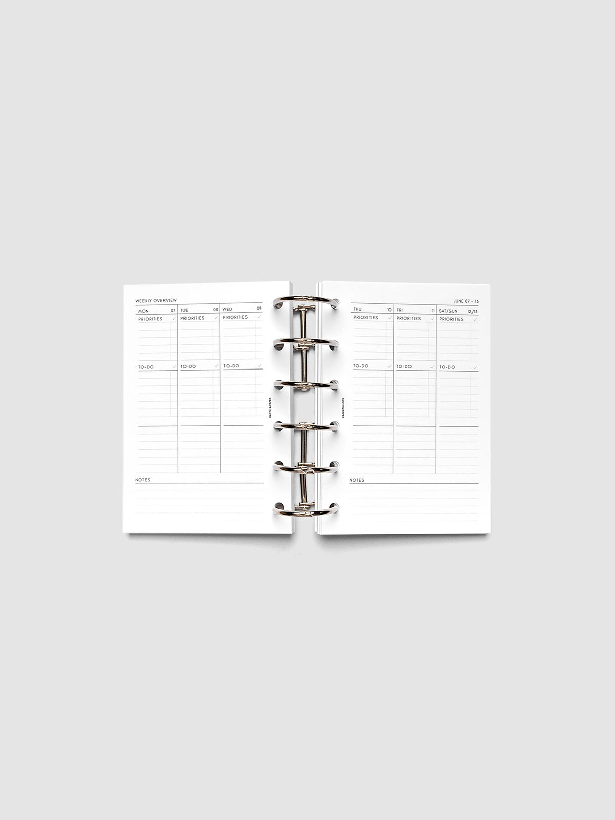 Both pages inside planner: 2027 Dated Weekly Task Planner Inserts, Monday Start, Pocket 6-Ring Punch, full week-on-two-pages spread showing blank vertical columns for each day with labeled priorities, to-do, and notes sections, Saturday and Sunday combined, and weekly notes section along the bottom, shown inside a planner