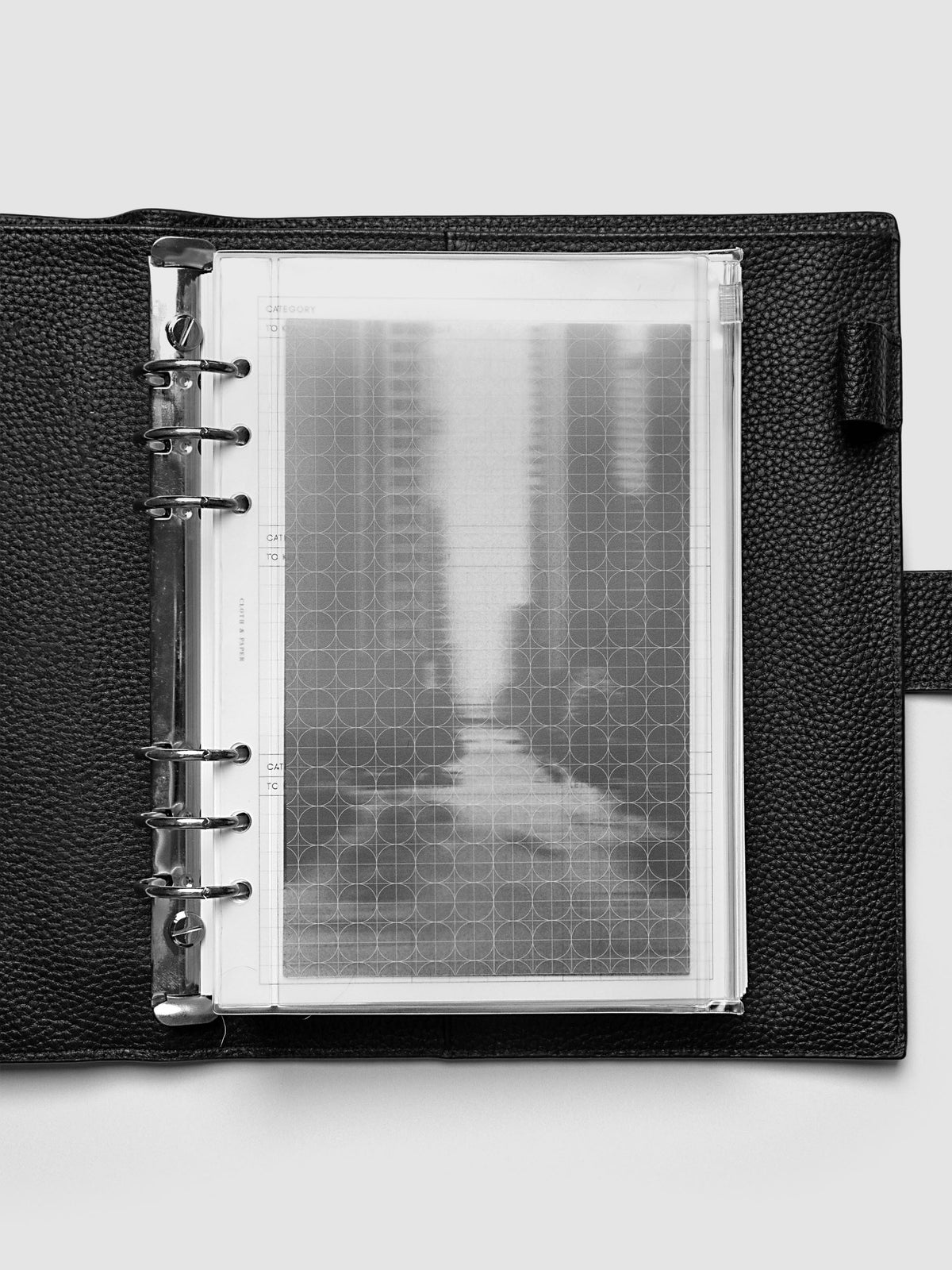 Side zipper transparent storage pouch for planners with decorative inner graph and photograph layers shown in an A5 planner agenda cover.