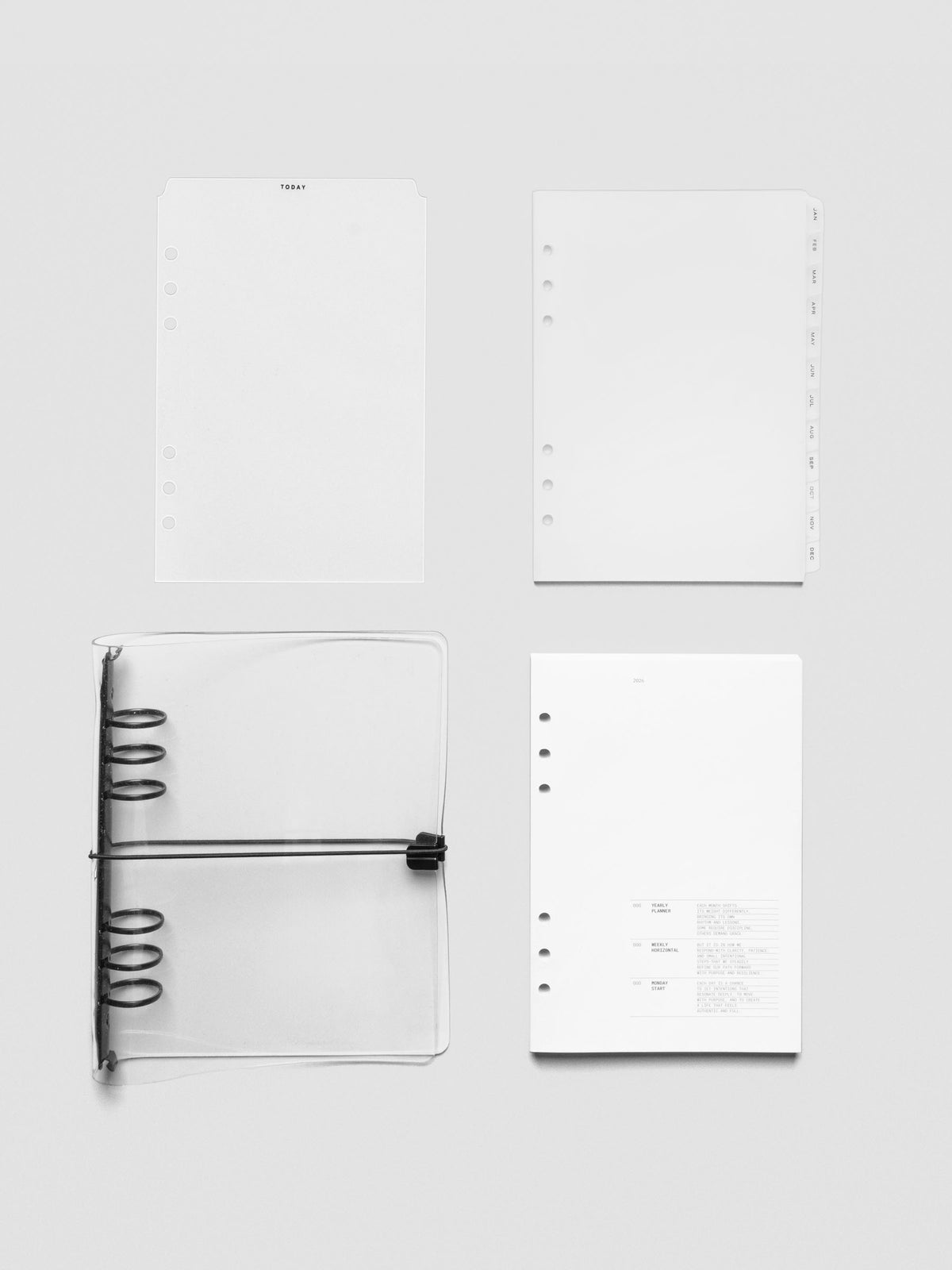 Flat lay of A5 6-Ring planner bundle contents including Today tab divider, monthly tab dividers, dated planner insert, and clear vinyl cover opened flat.