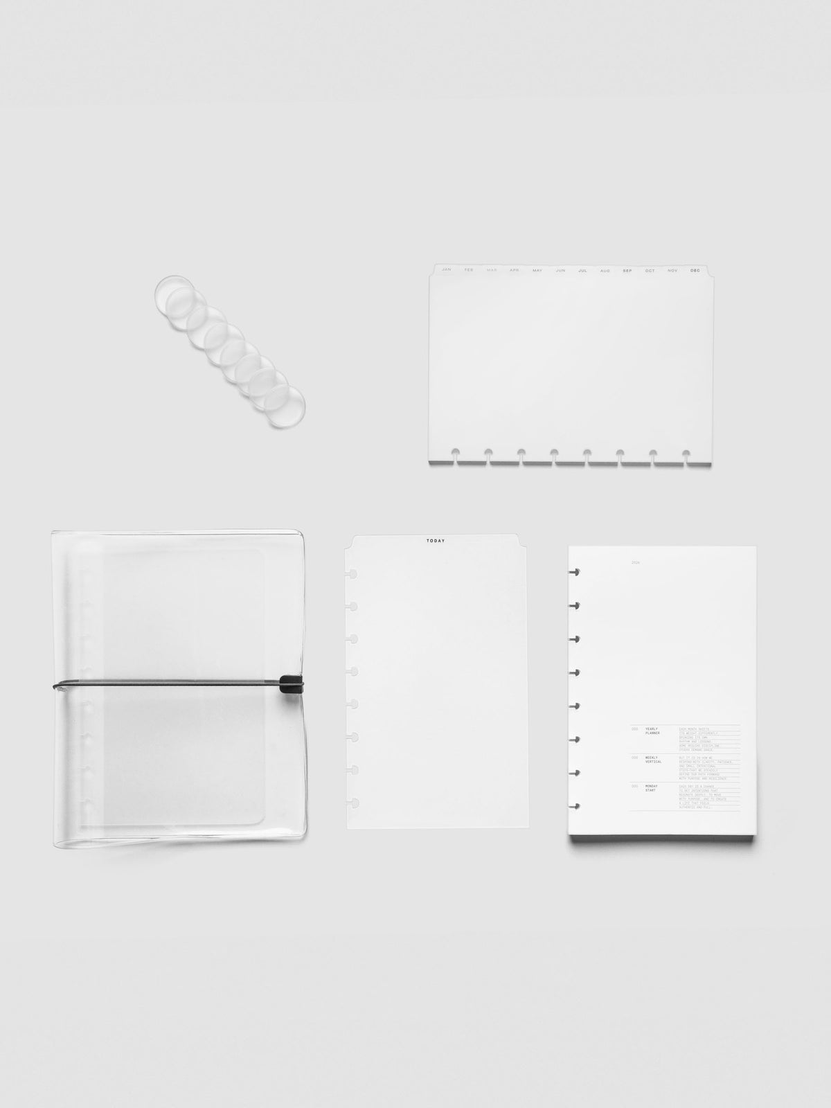 Flat lay of Half Letter 8-Disc planner bundle components including planner discs, clear vinyl cover, tab dividers, Today tab, and Vertical Weekly insert.
