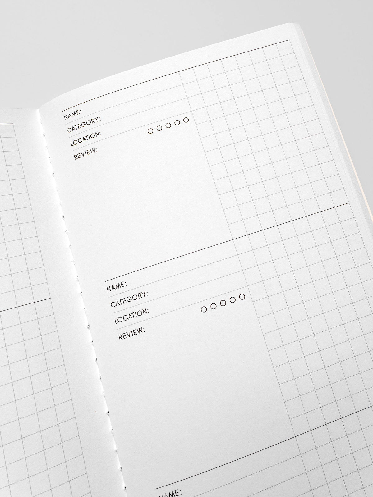 Travel Notebook A5 Slim Experience Tracker close up angled view of interior name category and location fields with grid paper