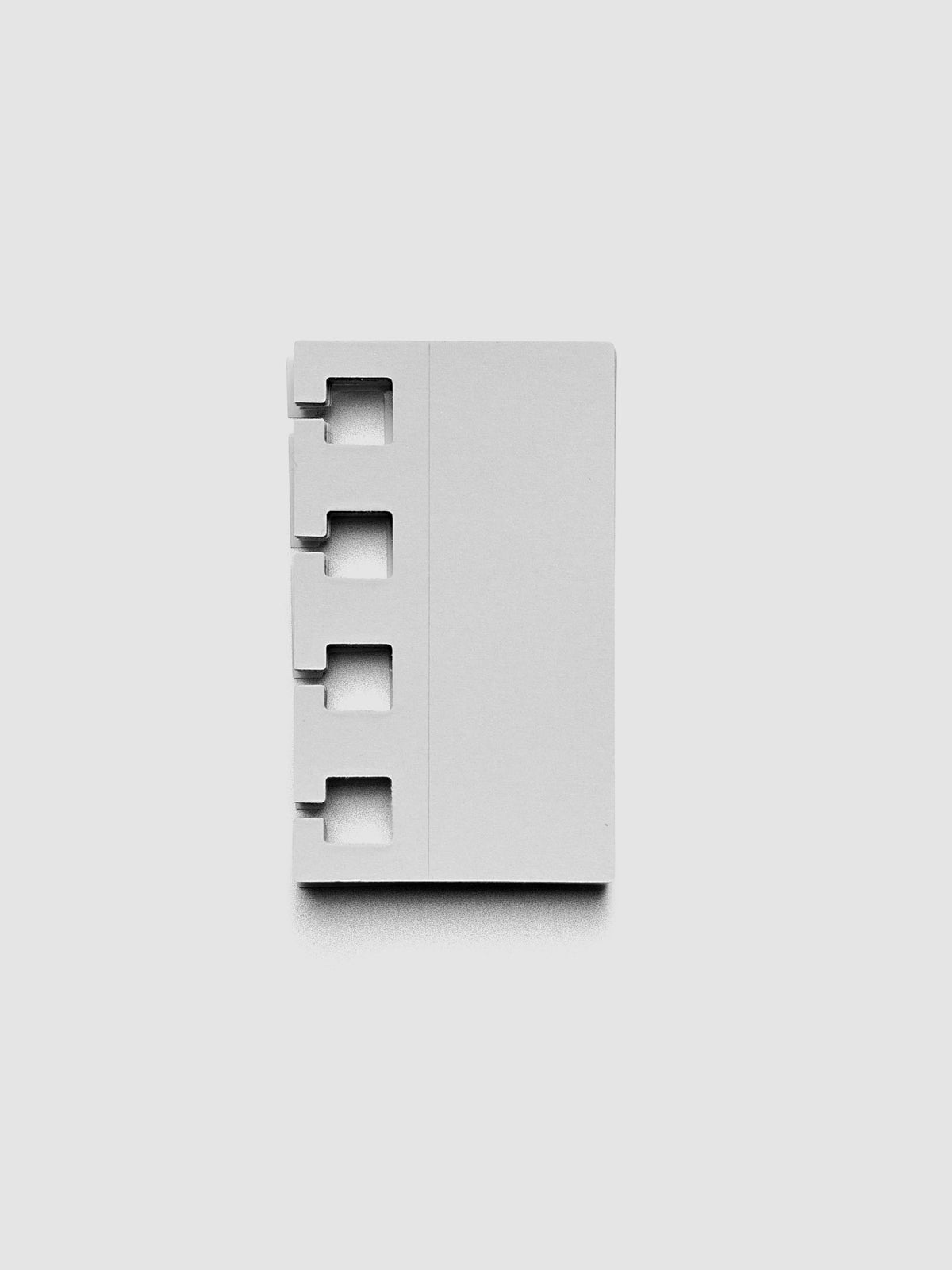 Stack of ash grey spiral system punch stickers on a grey background.
