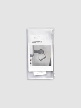 Pocket Plus travel notebook storage holder in clear frosted plastic, closed, with stickers and cards visible inside