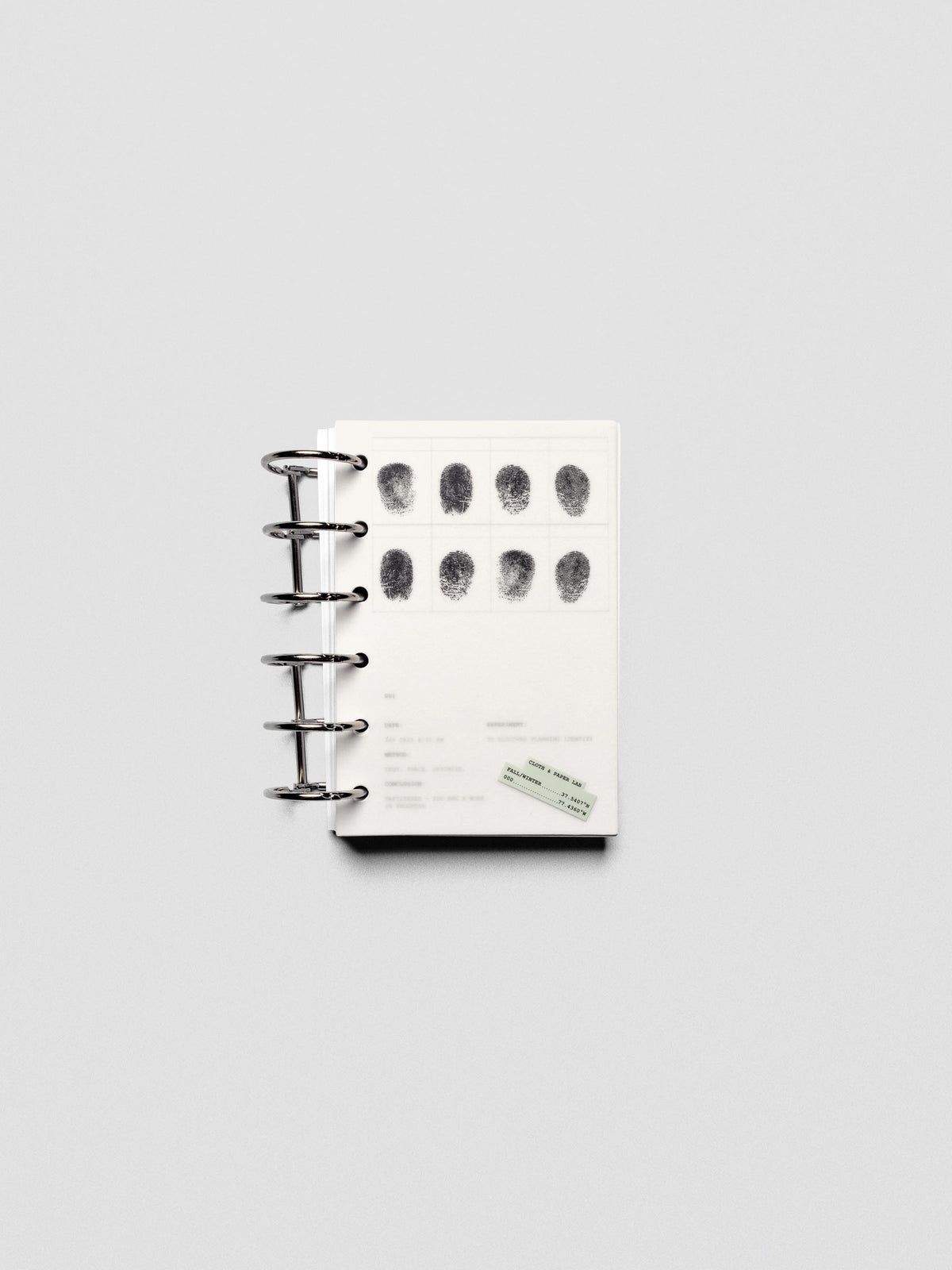 Two layered Pocket sized planner dashboards, one semi-transparent, one matte, featuring a fingerprint design shown in a ring bound planner.