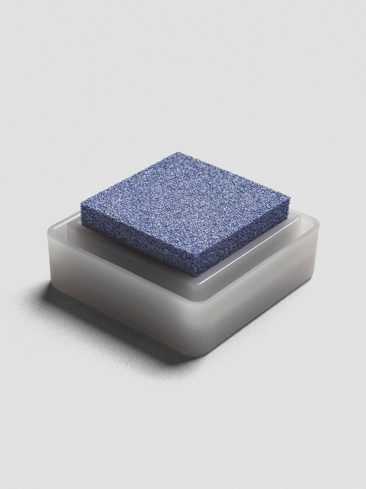 Light blue Artnic ink pad without lid, angled view of textured ink surface and white base.