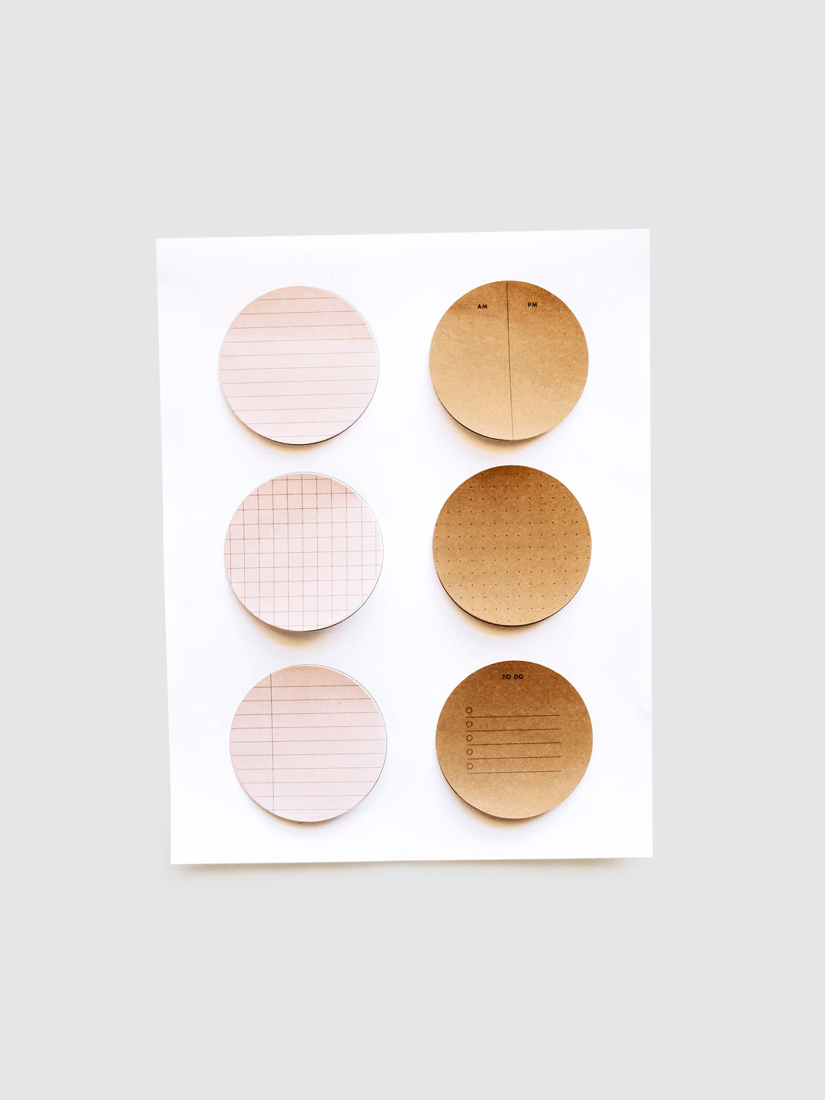 Brown and pink sticky notes printed using Circle Sticky Note Printables, stuck to their printing guide sheet.