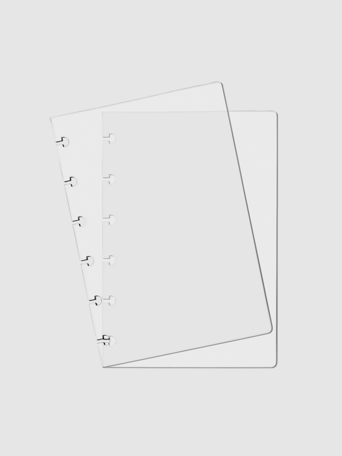 Crystal Clear Discbound Notebook Cover, CP Petite, Cloth and Paper. Two transparent notebook covers laid on top of one another with the top cover tilted slightly to the left.