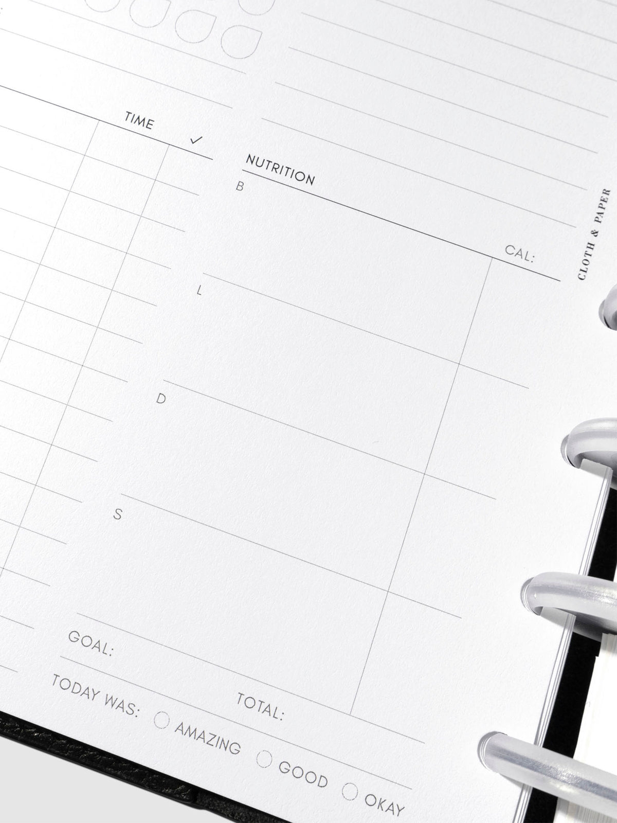 Closeup of daily wellness page inside a black leather planner.