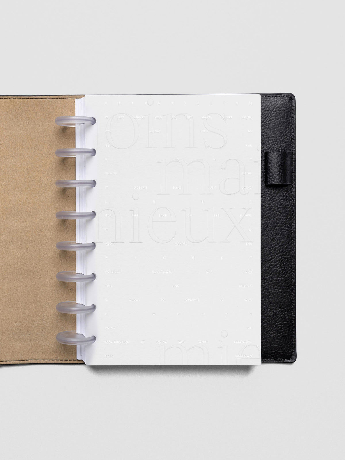 Essentialism Dashboard Duo reading "moins mai mieux" in size Half Letter; shown discbound in a leather folio.