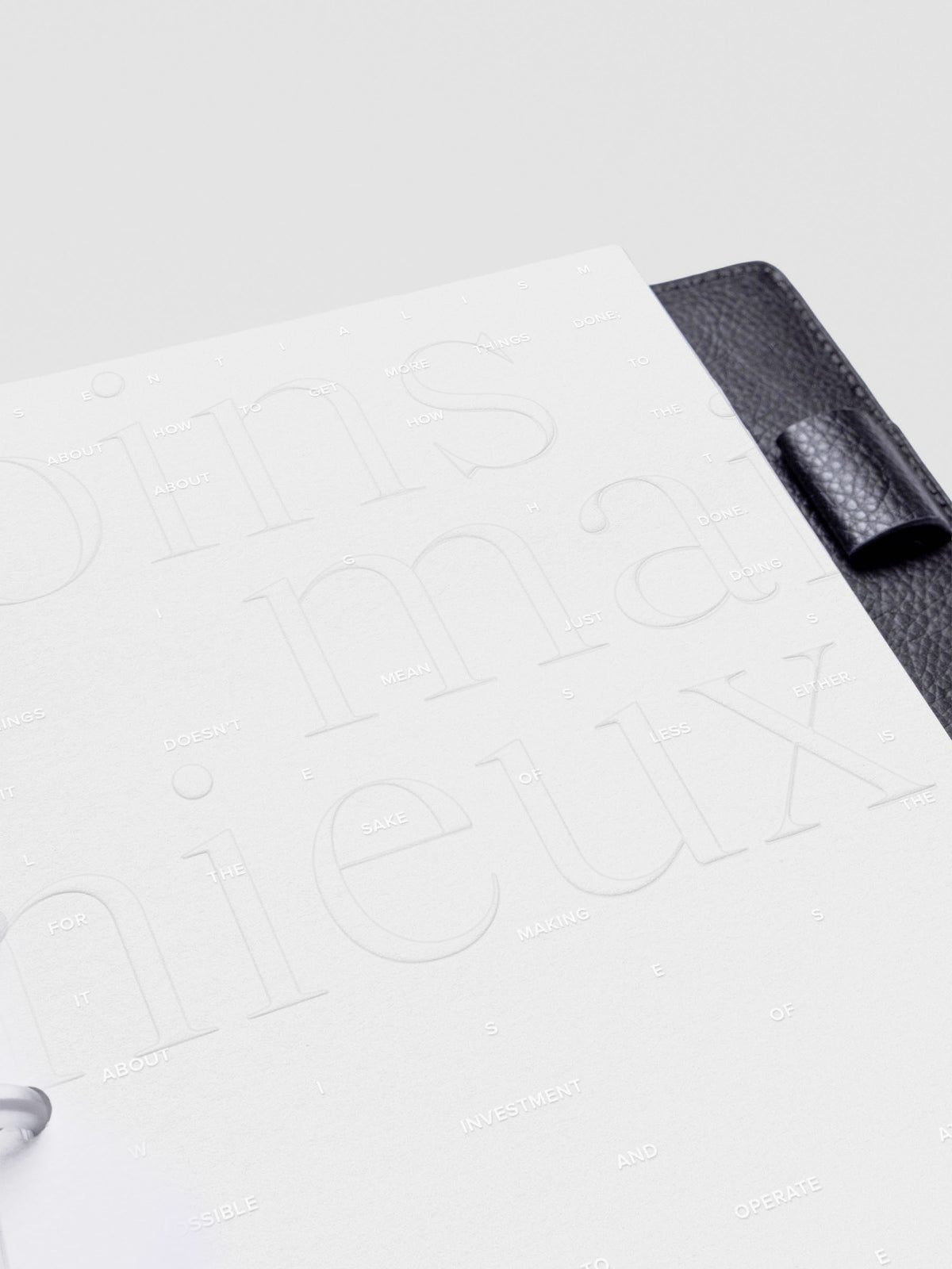 Essentialism Dashboard Duo reading "moins mai mieux" in size Half Letter; close up.