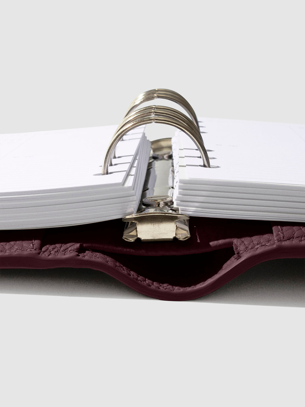 Close-up of the dark burgundy leather agenda ring mechanism.
