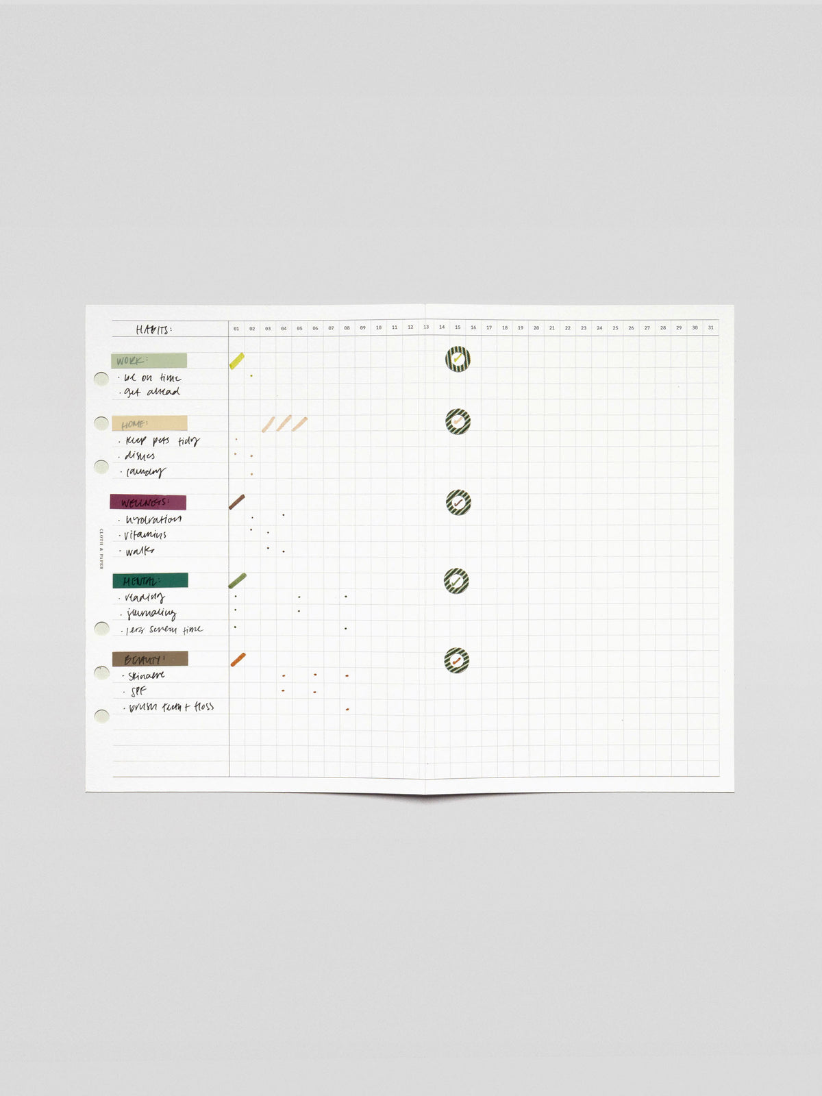 Wide view of the fold-out insert fully extended displaying a monthly habit grid with labeled tasks on the left and completed days marked with stickers.