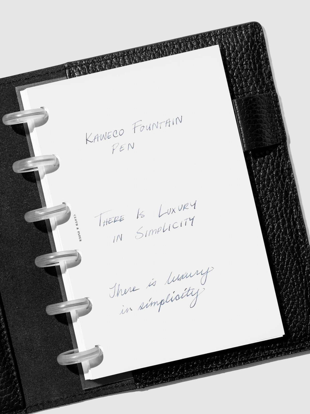 Writing sample shown in a black leather folio. 