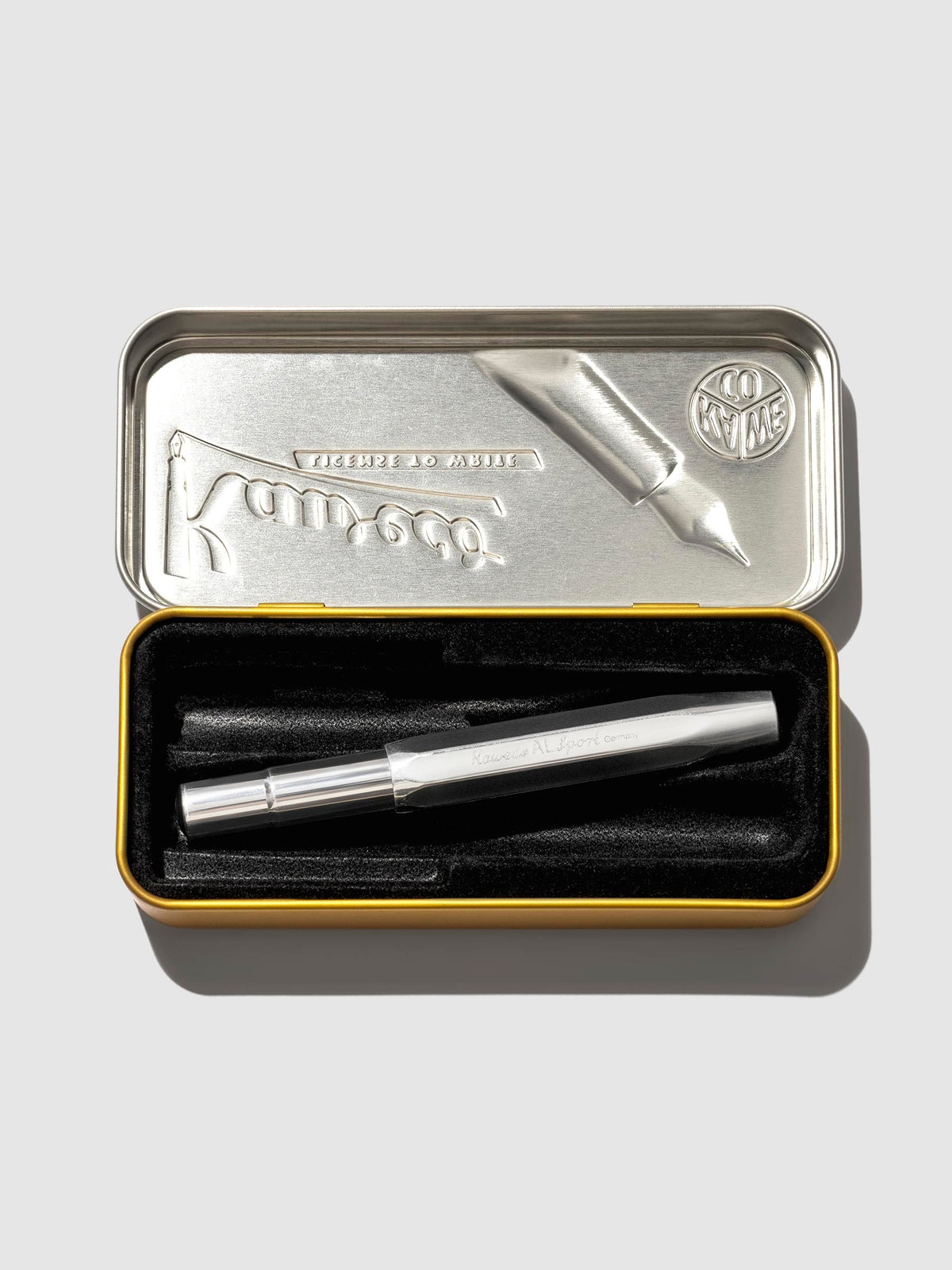 Pen displayed in its tin case on a neutral background.