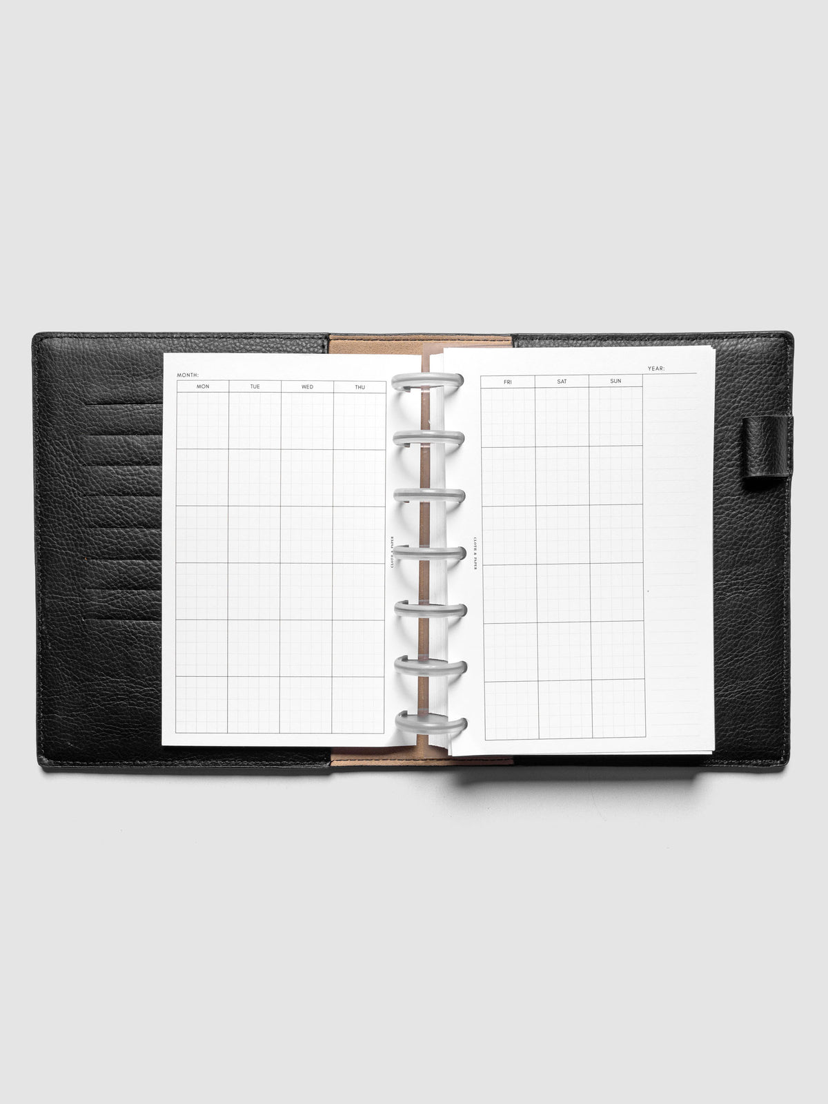 HP Mini Monthly Graph Planner Inserts shown discbound in a black leather folio.