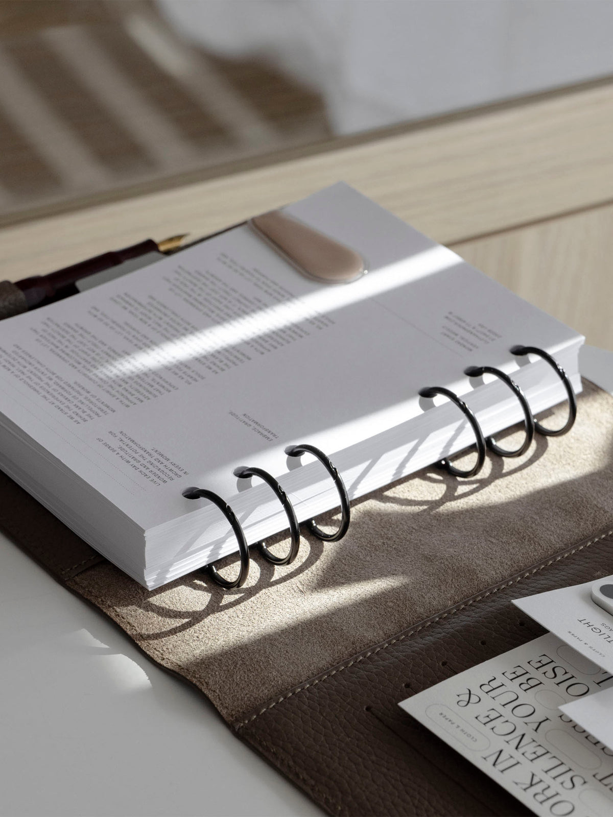 Black rings shown in use inside a brown leather planner folio.