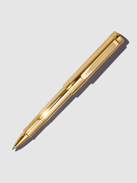 Scriveiner EDC Rollerball Pen, Gold, Cloth and Paper. Pen displayed on a neutral background.