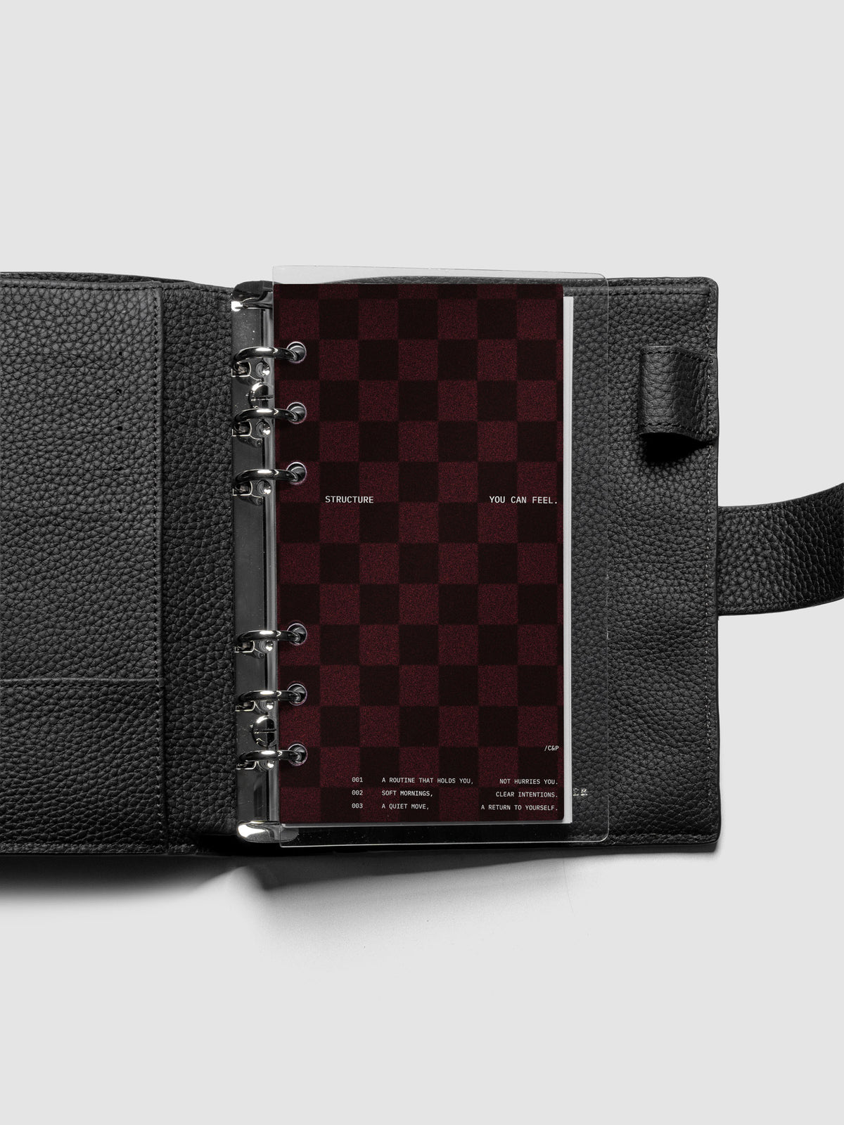 Personal sized velvet checkered dashboard in the color Bordeaux with crystal clear planner dashboard shown inside a black leather agenda.