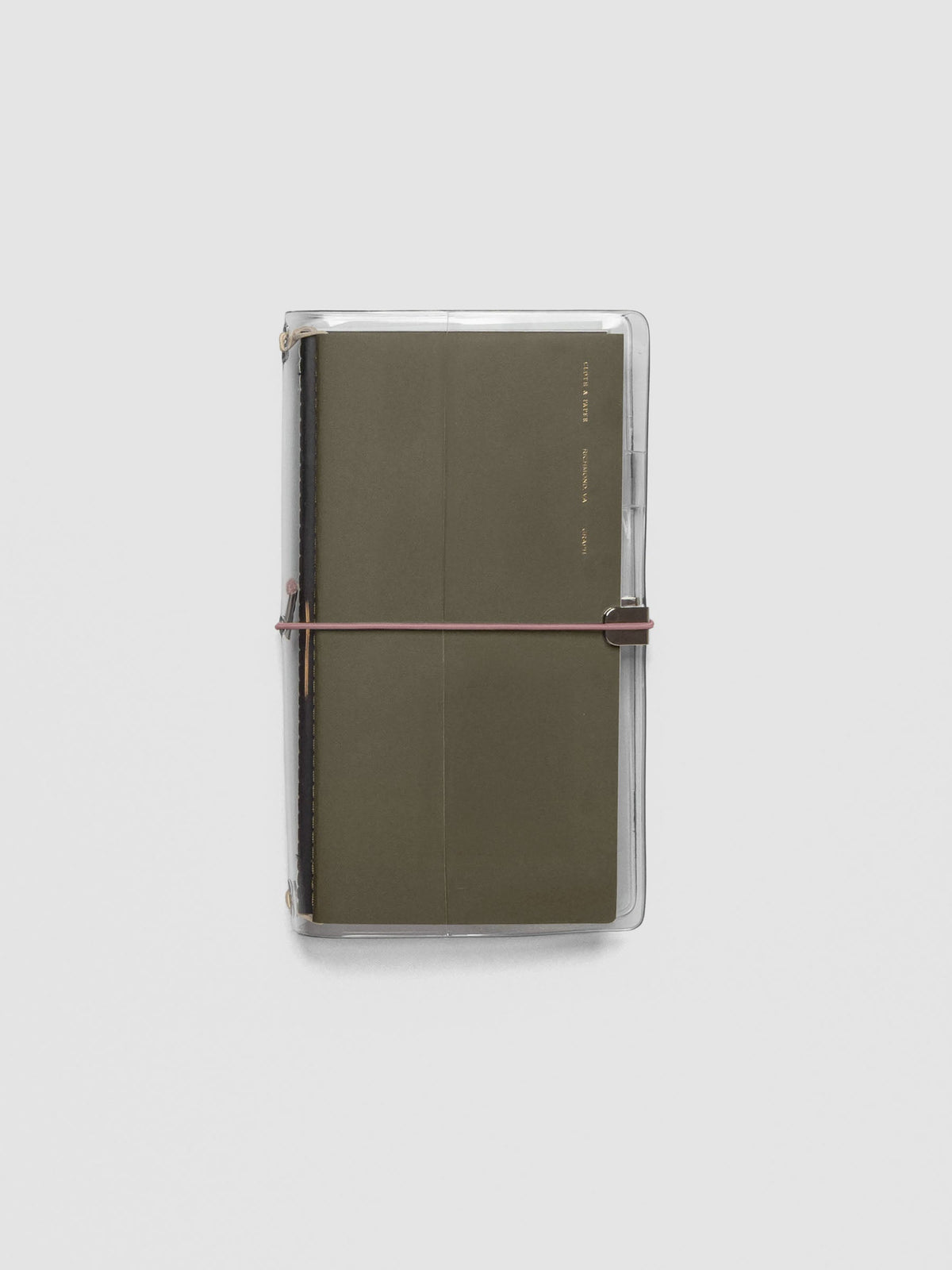 Pink exterior band in use with a clear vinyl cover with travel notebooks inside against a neutral background.