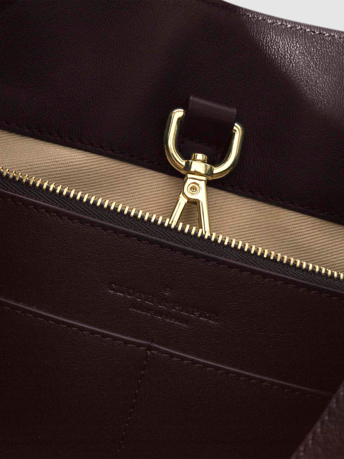 Top down view of bag showcasing its gold hardware. It secures the bag shut. Color shown is Madrid.