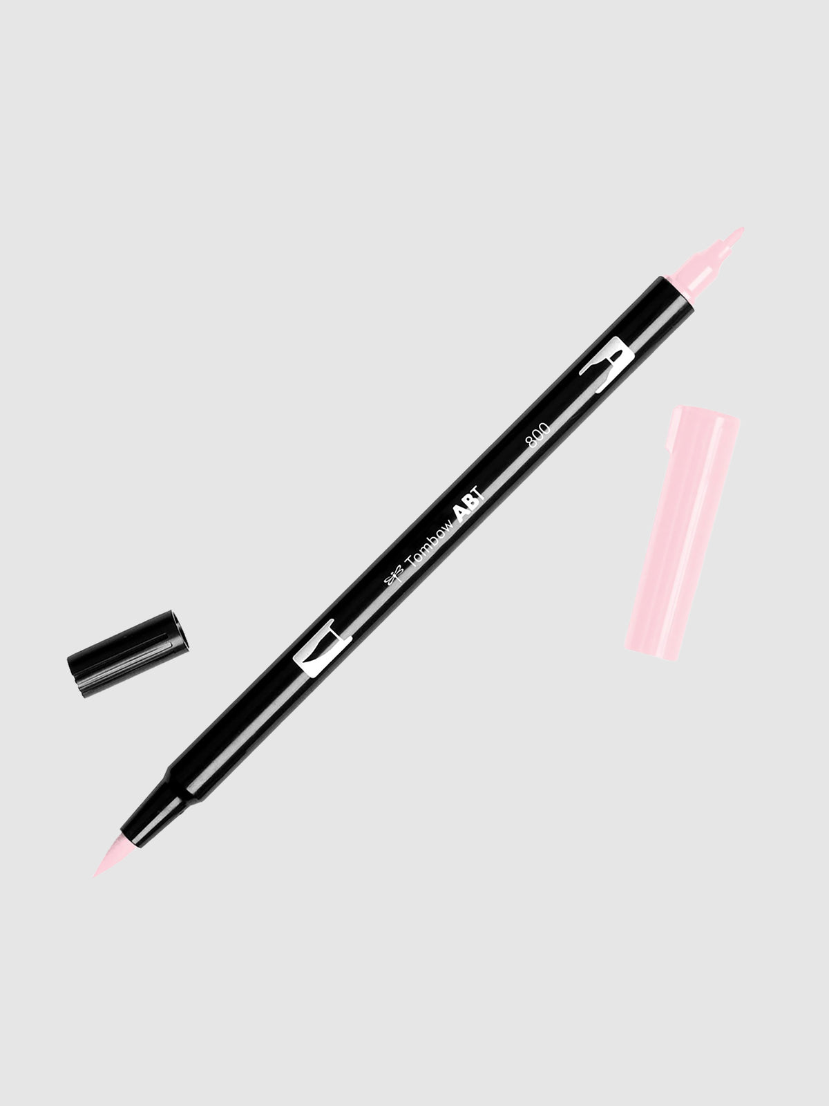 Tombow Dual Brush Art Marker, Pale Pink, Cloth & Paper. Art marker turned slightly to the right on a neutral background. It is uncapped on both ends showing the brush tip and fine tip.