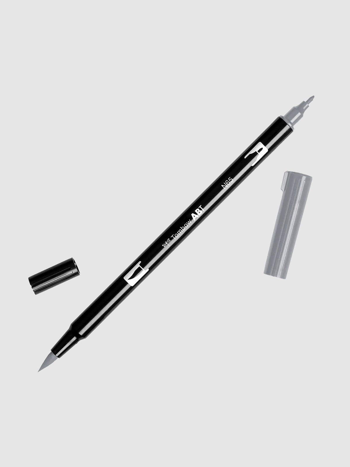 Tombow Dual Brush Art Marker, Cool Gray 5, Cloth & Paper. Art marker turned slightly to the right on a neutral background. It is uncapped on both ends showing the brush tip and fine tip.