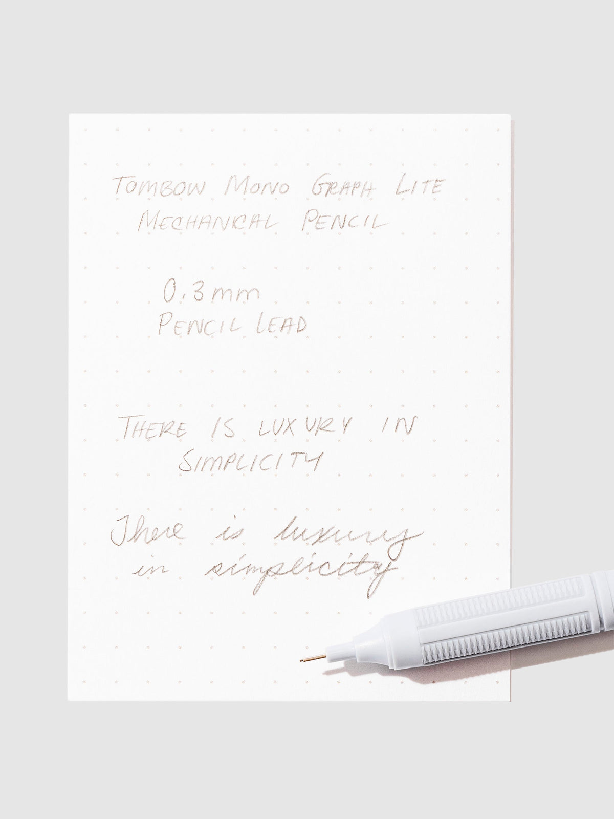 Writing sample with pencil displayed on a neutral background.