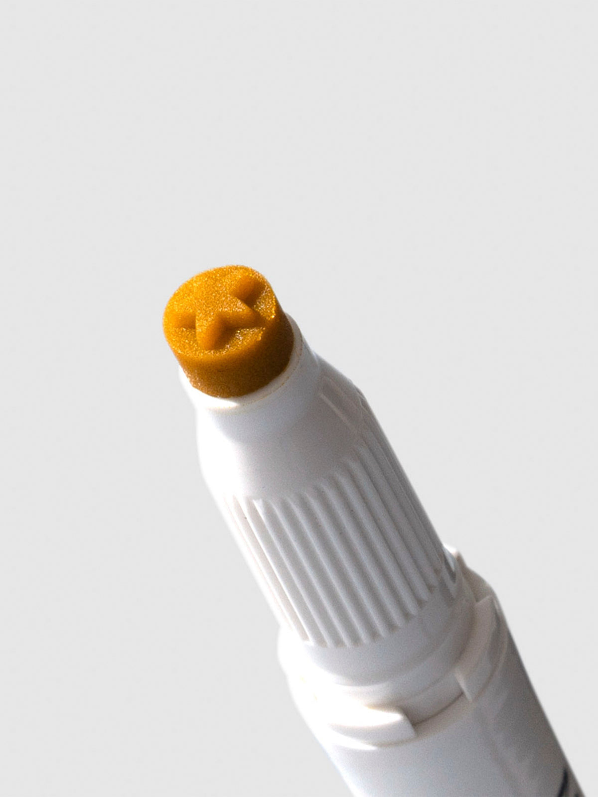 Closeup of gold highlighter's star shaped tip.