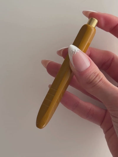 Kolo Tino Ballpoint Pen shown in use writing words on paper.