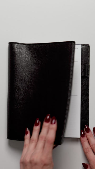 Person flipping through 30 Minute Time Block Planner inserts in a discbound planner.